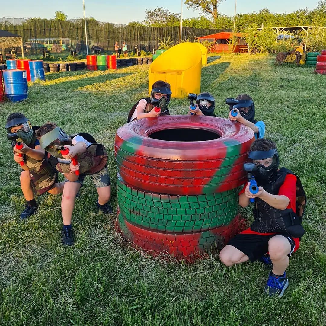 Grup de copii la joacă în spatele unui obstacol, teren KIDS